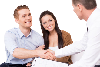 Happy young man shaking hand to financial agent while sitting together with his wife.