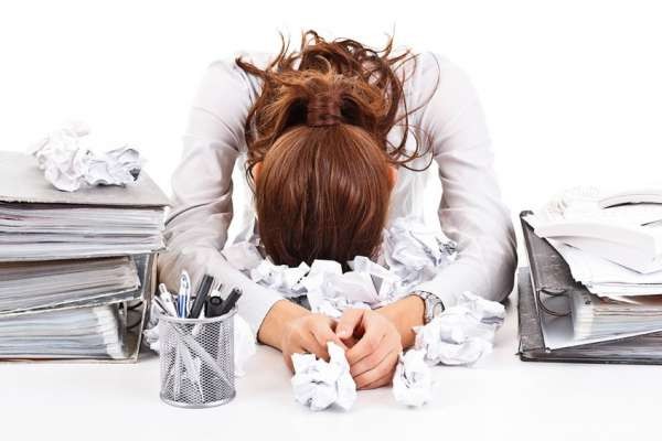 Tired and exhausted business woman with ring-binders.